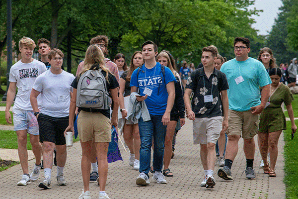 A group of students walking down a pathway on campus during a group tour